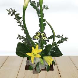Tall floral arrangement with white calla lilies and yellow lilies