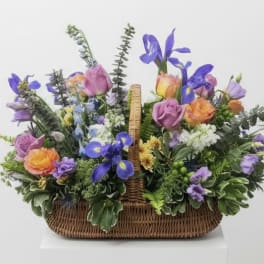 Basket arrangement of purple, pink, and orange flowers
