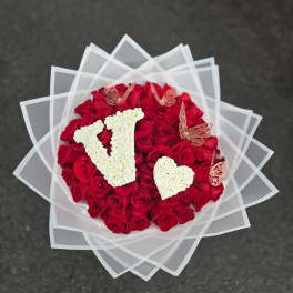 Round bouquet of red roses with white floral letters and butterfly accents