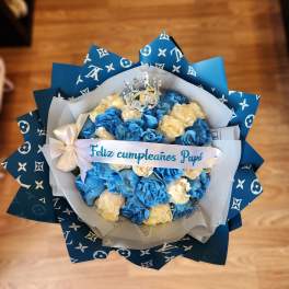 Blue and cream rose bouquet with a crown topper and birthday ribbon