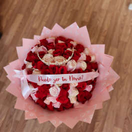 Bouquet of red and blush roses with a pink ribbon and tiara