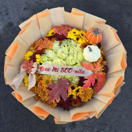 Fall bouquet of yellow and orange flowers with pumpkin decorations
