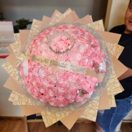 Large bouquet of pink roses with a tiara and ribbon