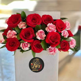 Red roses and pink carnations arranged in a white box