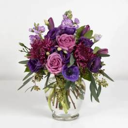 Purple and pink bouquet in a clear glass vase