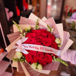 Red rose bouquet with a birthday ribbon and pale wrapping