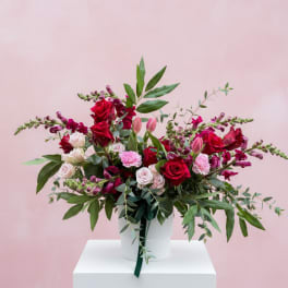 Bouquet of red and pink roses in a white hatbox