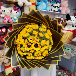 Bouquet of yellow sunflowers wrapped in dark brown paper