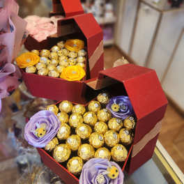 Heart-shaped gift boxes filled with chocolates and ribbon flowers