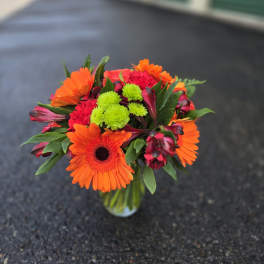 Bright orange and pink mixed bouquet in a glass vase