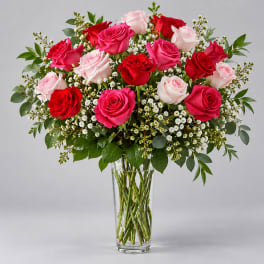 Bouquet of red, pink, and white roses in a clear glass vase