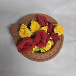 Red and yellow roses arranged on a round brown tray