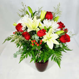 Bouquet of red roses and white lilies in a dark vase
