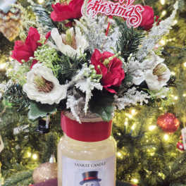 Holiday floral arrangement in a Yankee Candle jar with a Merry Christmas topper