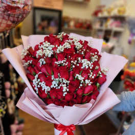 Bouquet of red roses with white baby's breath in pink wrapping