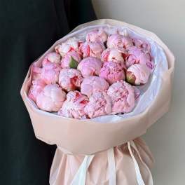 Bouquet of pale pink peonies wrapped in blush paper