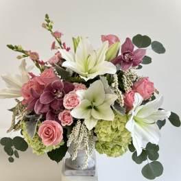 Pink roses and white lilies arranged in a gray vase