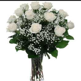 White roses and baby's breath in a clear glass vase