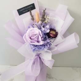 Lavender bouquet with a large rose and wrapped in pale purple paper