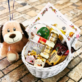 Gift basket with cookies, chocolates, and a plush dog