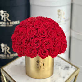 Round bouquet of red roses in a gold box