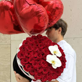 Heart-shaped red balloon bouquet with a round red rose arrangement and white orchids