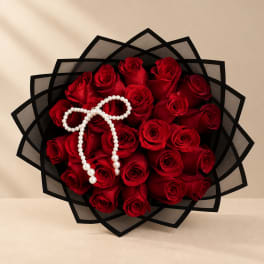 Bouquet of red roses wrapped in black paper with a pearl bow