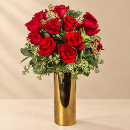 Red roses arranged in a tall gold vase