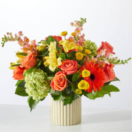 Mixed bouquet of roses, lilies, and gerbera daisies in a striped vase