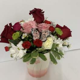 Mixed bouquet in a pink vase with a butterfly decoration