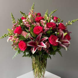 Bouquet of pink roses and lilies in a clear glass vase