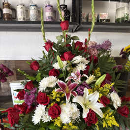 Large mixed bouquet with red roses, white lilies, and yellow filler flowers
