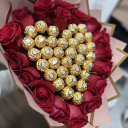 Heart-shaped bouquet of red roses with gold-wrapped chocolates