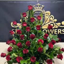 Tall arrangement of red roses in a gold pedestal vase