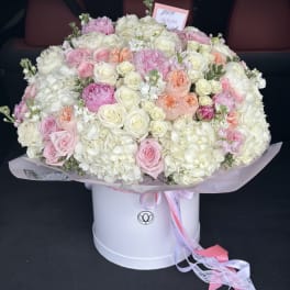 Large bouquet of pink and white roses and hydrangeas in a white hat box