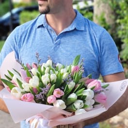 Bouquet of pink and white tulips wrapped in pale pink paper