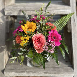 Mixed bouquet with pink and yellow flowers in a striped vase