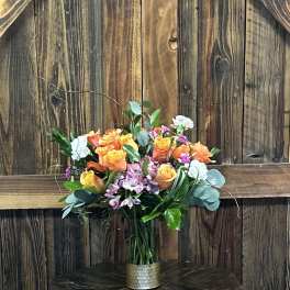 Bouquet of orange and yellow roses in a metal vase