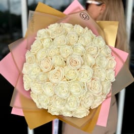 Large bouquet of cream roses wrapped in pink and tan paper