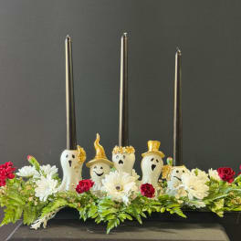 Halloween centerpiece with ghost candle holders and red and white flowers