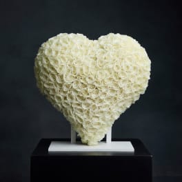 Heart-shaped arrangement of white roses on a stand