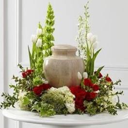 Red and white floral arrangement around a beige urn
