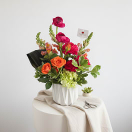 Bouquet of orange and pink flowers in a white vase