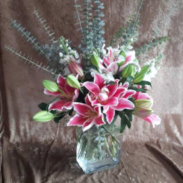 Pink lilies and eucalyptus in a clear glass vase