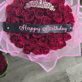 Bouquet of deep pink roses with a jeweled tiara and Happy Birthday ribbon