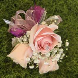 Pink rose boutonniere with baby's breath and ribbon accents