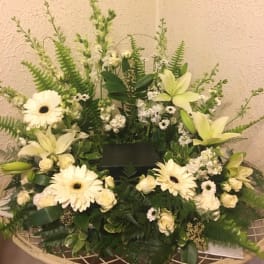 White floral sympathy arrangement with lilies and gerbera daisies