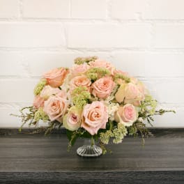 Blush pink roses arranged in a clear glass vase