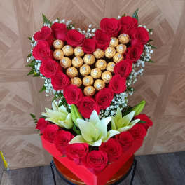 Heart-shaped rose and chocolate arrangement with white lilies