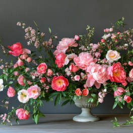 Large pink floral arrangement in a pedestal vase